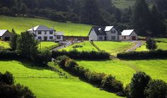 a large house sitting on top of a lush green hillside