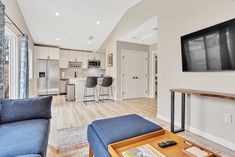 a living room filled with furniture and a flat screen tv mounted on the wall above a fireplace