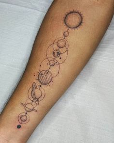 a tattoo on the arm of a person with planets and sun in it's center