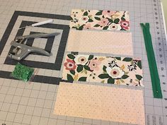 scissors, ruler and fabric laid out on top of a cutting mat with flower designs