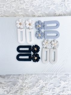 the letters are made out of paper and decorated with flower clips on a white lace tablecloth