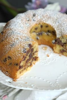 a blueberry bunt cake on a white plate with a piece missing from it