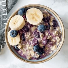 a bowl of oatmeal with blueberries and banana slices on the side