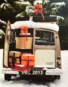 an old vw bus is covered in snow and presents