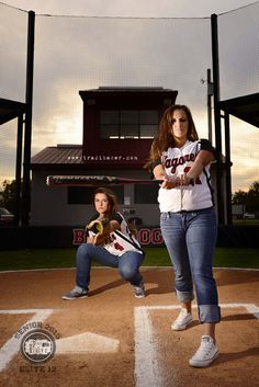 two girls are playing baseball on the field