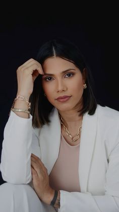 a woman in a white suit posing for a photo with her hands on her head