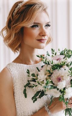 a woman holding a bouquet of flowers in her hand