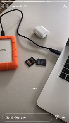 an orange and white device sitting on top of a table next to a laptop computer