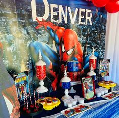 a spiderman themed birthday party with balloons and desserts