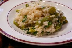 a white plate topped with rice and green beans on top of a red rimmed table