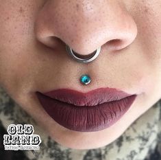 a woman's nose has a piercing on it and is wearing a ring around her nose