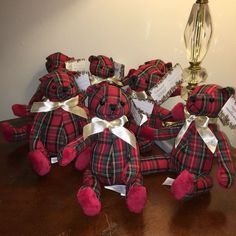 a group of red teddy bears sitting on top of a wooden table