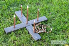 a wooden cross sitting in the grass with several sticks sticking out of it's center