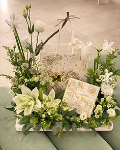 a bouquet of white flowers sitting on top of a table next to a shopping bag