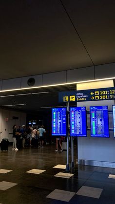 an airport terminal with people waiting for their luggage