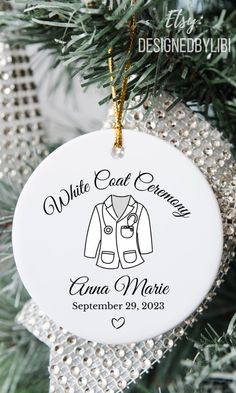 an ornament hanging from a christmas tree that says, white coat ceremony and ann marie