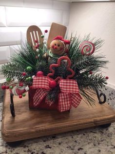 a wooden tray with a teddy bear and candy canes in it on top of a counter