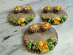 three decorative trays with flowers on them sitting on a marble counter top next to candles