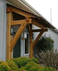 an outside view of a house with a wooden porch and roof over the front door