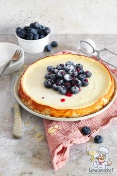 a cheesecake topped with blueberries on top of a table