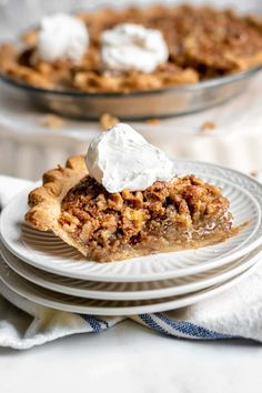 a slice of pecan pie on a plate with whipped cream and other dessert items