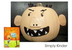 a pumpkin with an image of a monster's face on it and a book