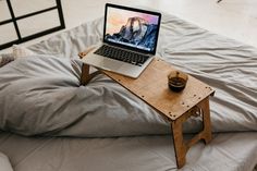 an open laptop computer sitting on top of a wooden table next to a cup of coffee