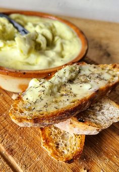 bread slices with cream cheese spread in a bowl on a cutting board next to a spoon