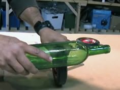 a person is opening a green wine bottle