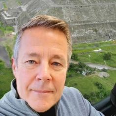 a man taking a selfie in front of an aerial view