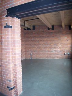 an empty parking garage with brick walls and beams