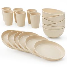 a bunch of plates and cups are arranged on a white surface