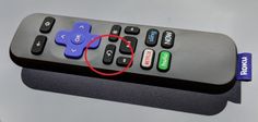 a close up of a remote control with an arrow pointing to the button on it