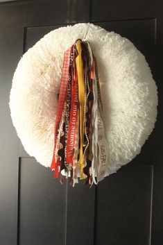 a bunch of ribbons hanging from the side of a door hanger on a black door