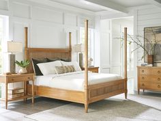 a bedroom with white walls and wood furniture