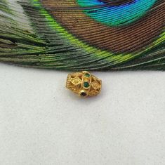 a close up of a peacock feather with a gold ring on it's side