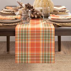 the table is set with plaid cloths and place settings