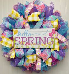 a colorful wreath with the words hello spring on it and some ribbons attached to it