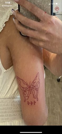 a woman's arm with a butterfly tattoo on the left side of her body