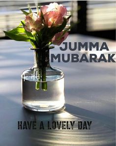 there is a small vase with flowers in it on the table that says jumma mubarak have a lovely day