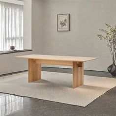 an empty room with a table and vases on the floor in front of a window