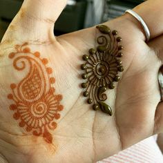 a woman's hand with an intricate hendi design on her left wrist and right hand