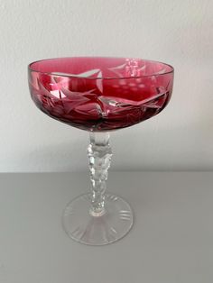 a red glass bowl sitting on top of a table