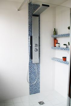 the shower head is attached to the wall in this bathroom with blue and white tiles