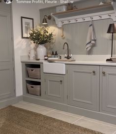 a white sink sitting under a mirror next to a counter top with baskets on it