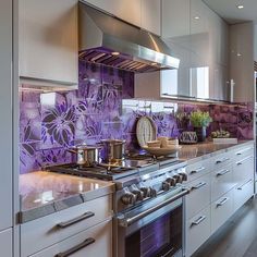 a kitchen with stainless steel appliances and purple tiles on the backsplash, along with white cabinets