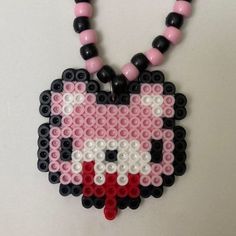 a necklace made out of legos and beads with a cat face on the front