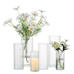 several vases with flowers and candles in them