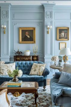 a living room with blue couches and paintings on the walls