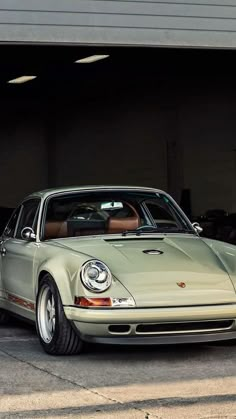 an old white porsche parked in a garage